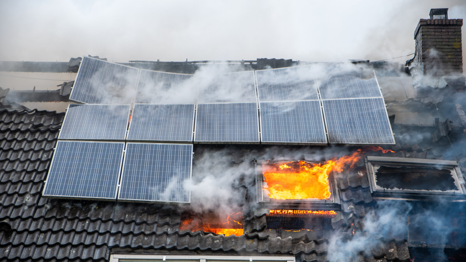 Ein brennendes Dachgeschoss. Auf dem Dach ist auch eine Photovoltaikanlage installiert.